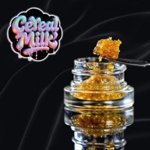 Cereal Milk strain cannabis concentrate close-up – premium THC distillate dab with glossy amber texture, dripping from dab tool on black background, high-quality resin extract from Tastebudz Genetics